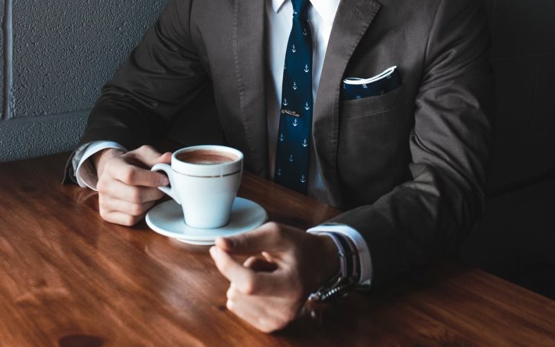 Person sitzt mit Kaffeetasse am Tisch | Foto: Andrew Neel, unsplash.com